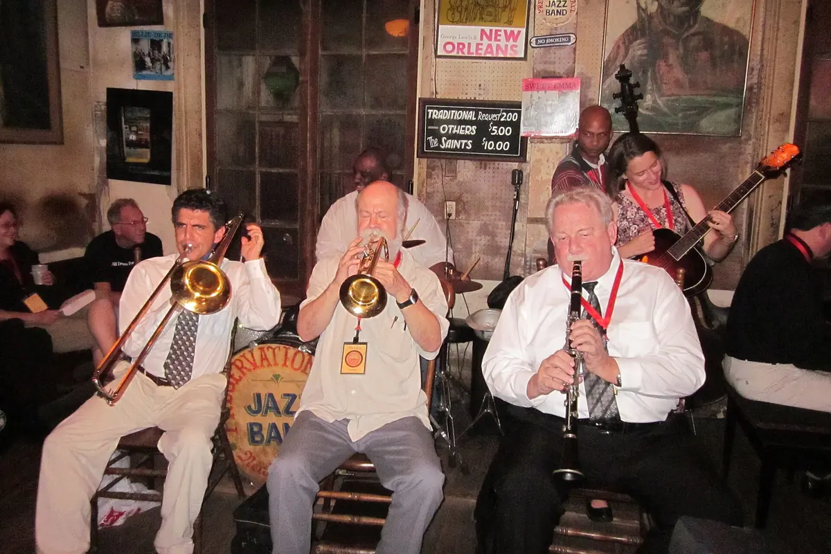 A trombone, a trumpet and a clarinet played side by side by three musicians at Preservation Hall in New Orleans